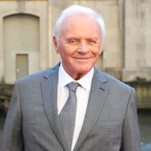 Actor Anthony Hopkins smiling in a suit, a well-known figure with Autism Spectrum Disorder.